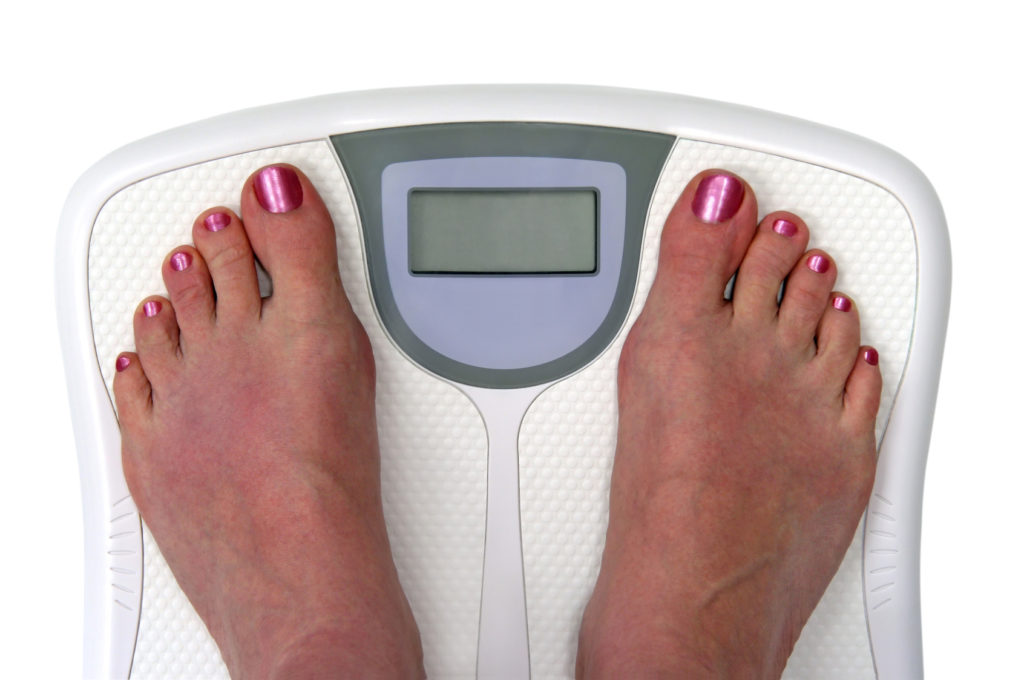 Feet on a bathroom scale. Sceen is blank so you can enter your own numbers or text. Isolated. Includes clipping path.